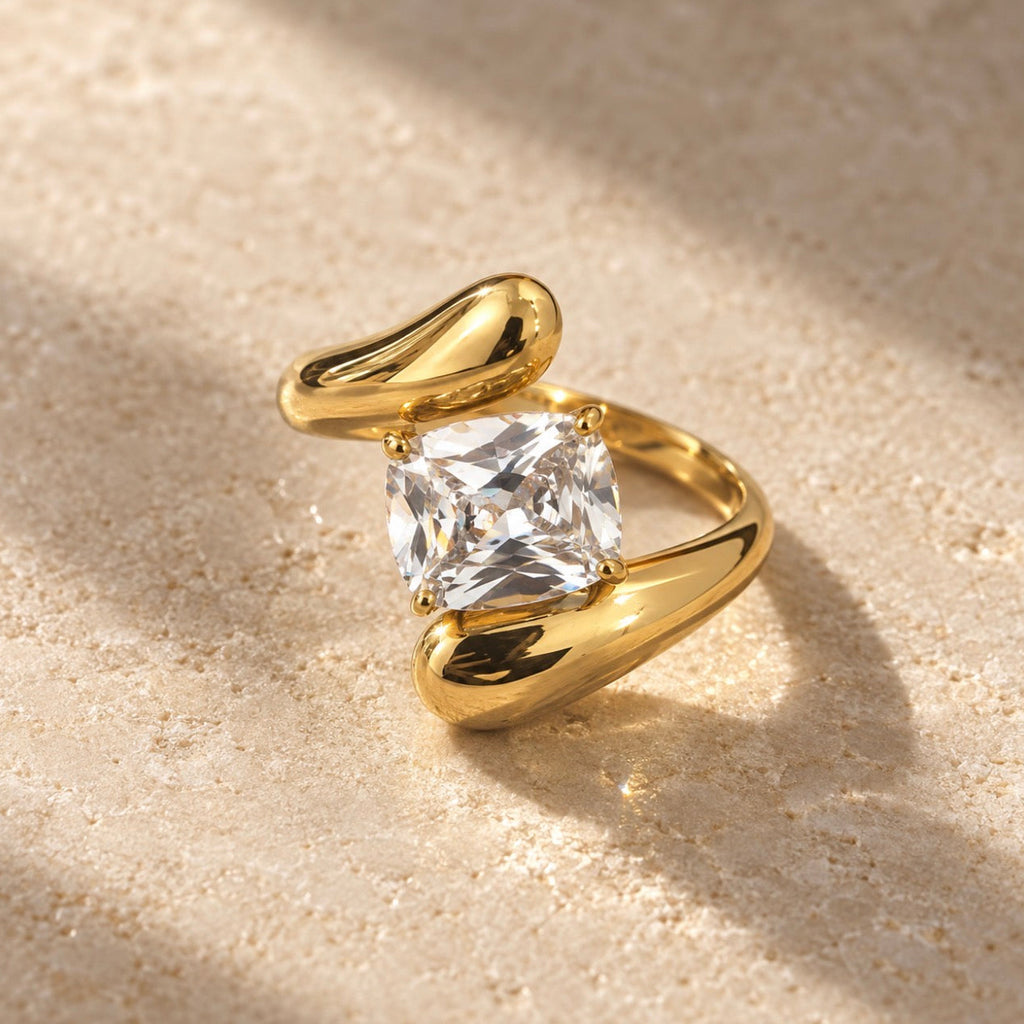La Bague Mut incarne une élégance contemporaine à travers une silhouette sculpturale, audacieuse et résolument sophistiquée. Pensée pour les femmes à la recherche d’un bijou distinctif et lumineux, cette bague haut de gammesublime naturellement la main grâce à son design ouvert, ses courbes généreuses et sa pierre centrale aux reflets lumineux.
Son design ouvert et asymétrique se distingue par une composition originale dans laquelle deux extrémités sculpturales viennent encadrer délicatement la pierre centr