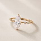 ### Bague de la Marquise

La **Bague de la Marquise** est une pièce majestueuse, pensée pour celles qui apprécient les bijoux lumineux et sophistiqués.

Confectionnée en **laiton doré**, elle se distingue par ses motifs en écailles délicatement **micro-pavés de zircons incolores**, qui captent la lumière sous chaque angle. En son centre, un imposant **cristal incolore de forme ovale** apporte profondeur, éclat et caractère à la création.

Son allure précieuse en fait le bijou idéal pour sublimer une tenue d