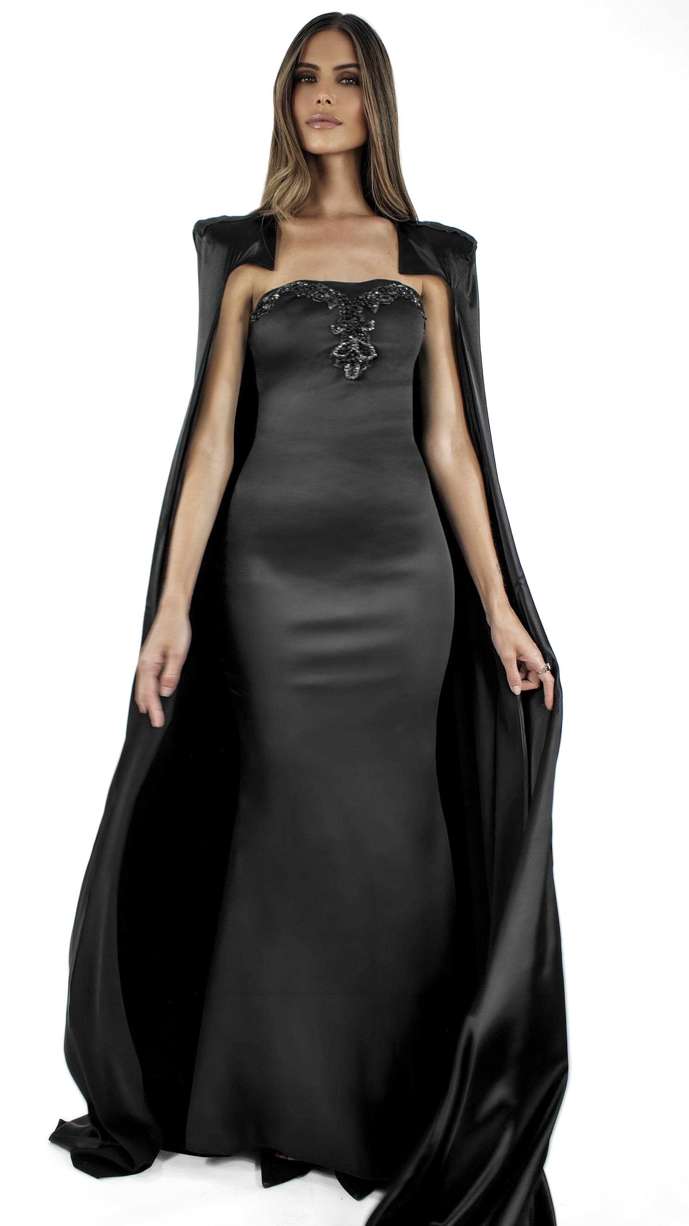 La robe longue Lampétie avec sa cape Circé en noir&nbsp;sont brodées à la main.

Robe :&nbsp;

Bustier col-cœur couvrant l’intégralité de la poitrine en la rehaussant et en épousant ses formes.
Sans bretelles ni armatures.
Arabesques de perles et sequins dessinant le cœur de la poitrine.
Fermeture zippée invisible au dos de 32 cm.
Fente au milieu du bas du dos de la robe qui couvre les chaussures.
Coupe ajustée affinant la taille.Soie naturelle d’un fini mat opaque.
Confectionnée en taille standard ou en su